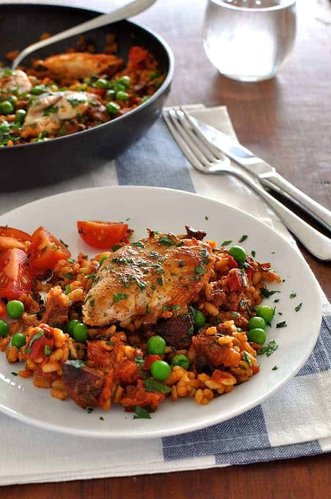 Quick paella with chorizo and chicken on a white plate
