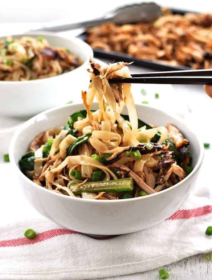 Chopsticks picking up Crispy Shredded Chicken Noodle Stir Fry from a bowl.