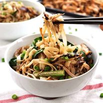 Chopsticks picking up Crispy Shredded Chicken Noodle Stir Fry from a bowl.