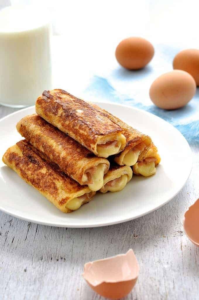 Ham and Cheese French Toast Roll Ups stacked on a plate