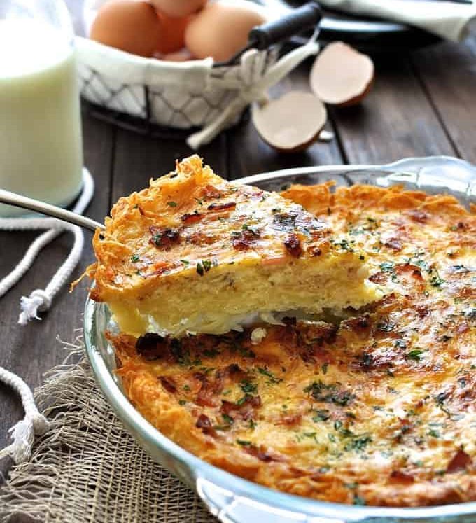 Slice of Hash Brown Crust Quiche Lorraine being lifted out a pie dish.