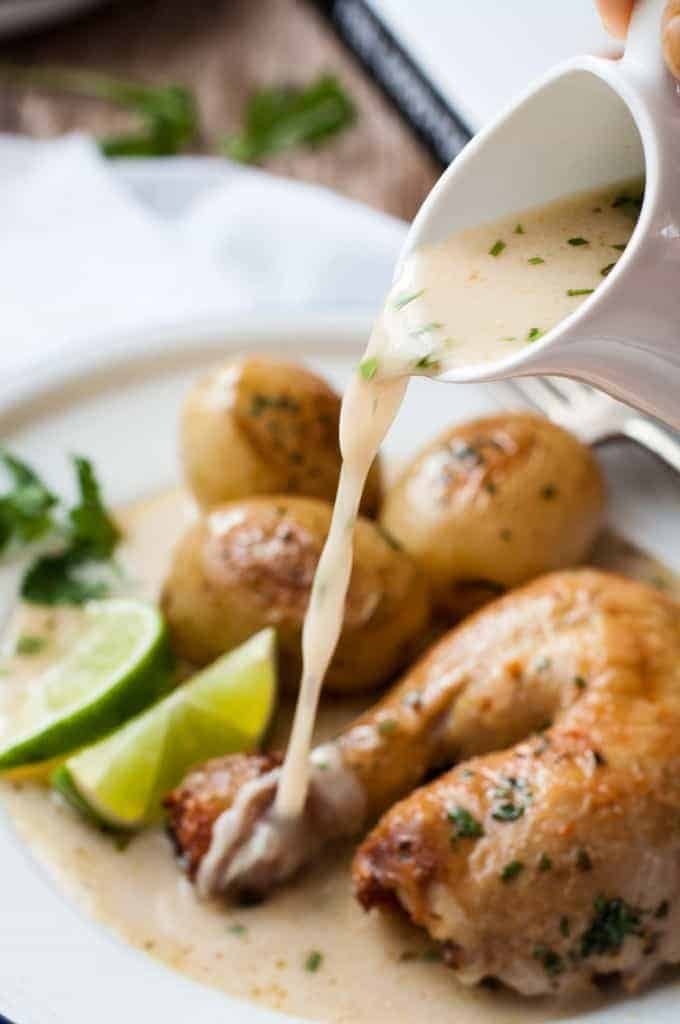 Broth being poured over pot roasted chicken