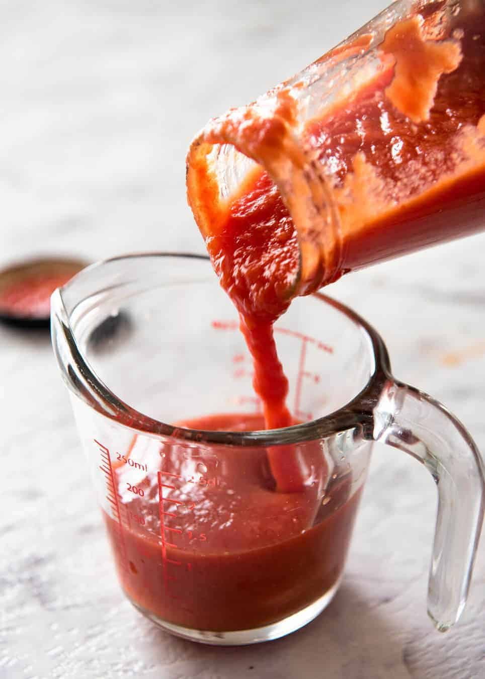 Closeup of tomato passata being poured