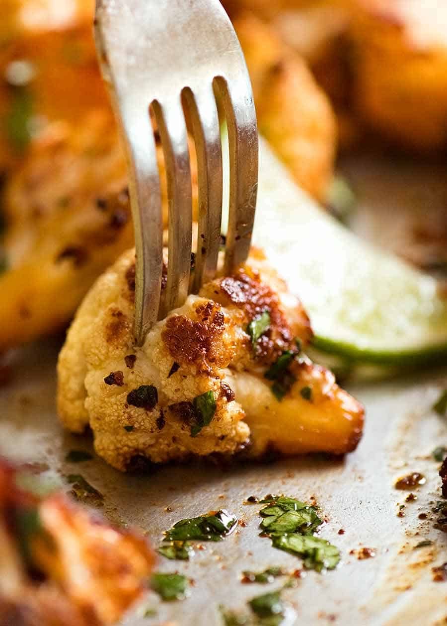 Close up of fork stabbing roasted cauliflower