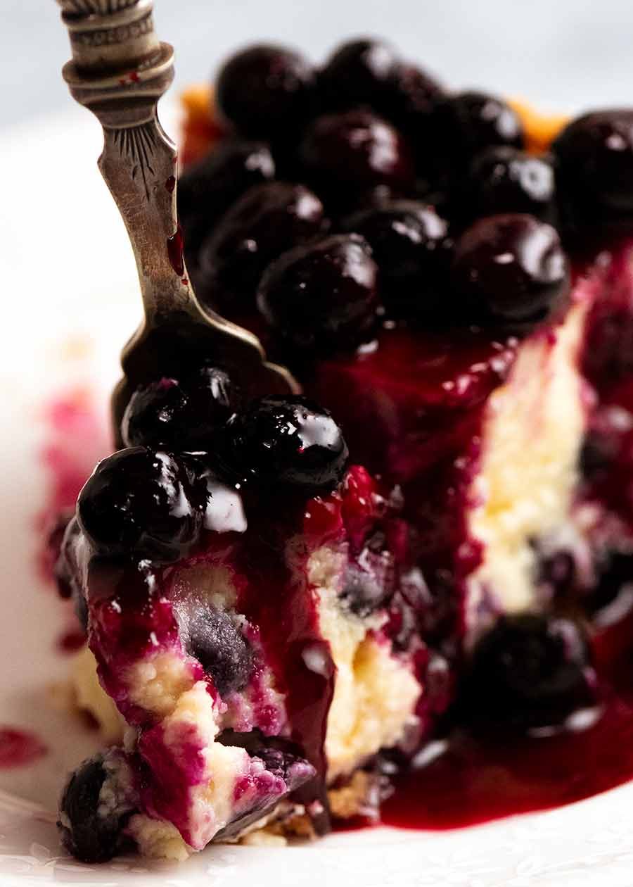 Fork cutting into Blueberry Cheesecake
