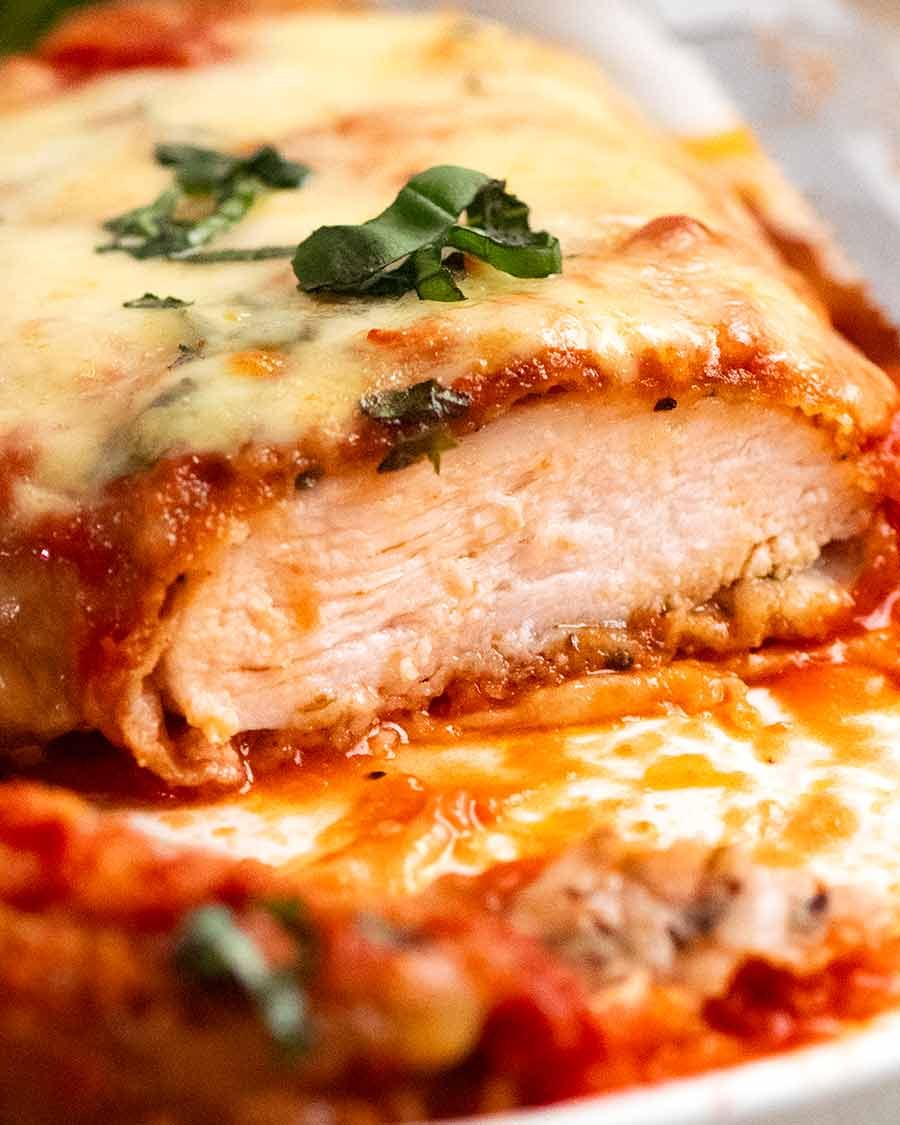 Piece of Chicken Parmigiana (Chicken Parmesan) cut open to show how juicy the chicken is inside