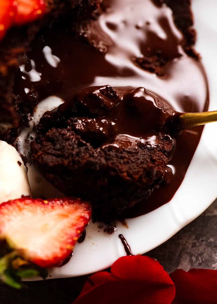 Close up of spoon scooping up Molten Chocolate Cake with chocolate lava