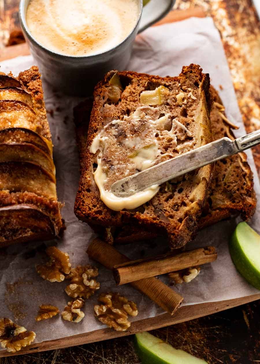 Spreading butter onto a lightly toasted slice of Cinnamon Apple Bread