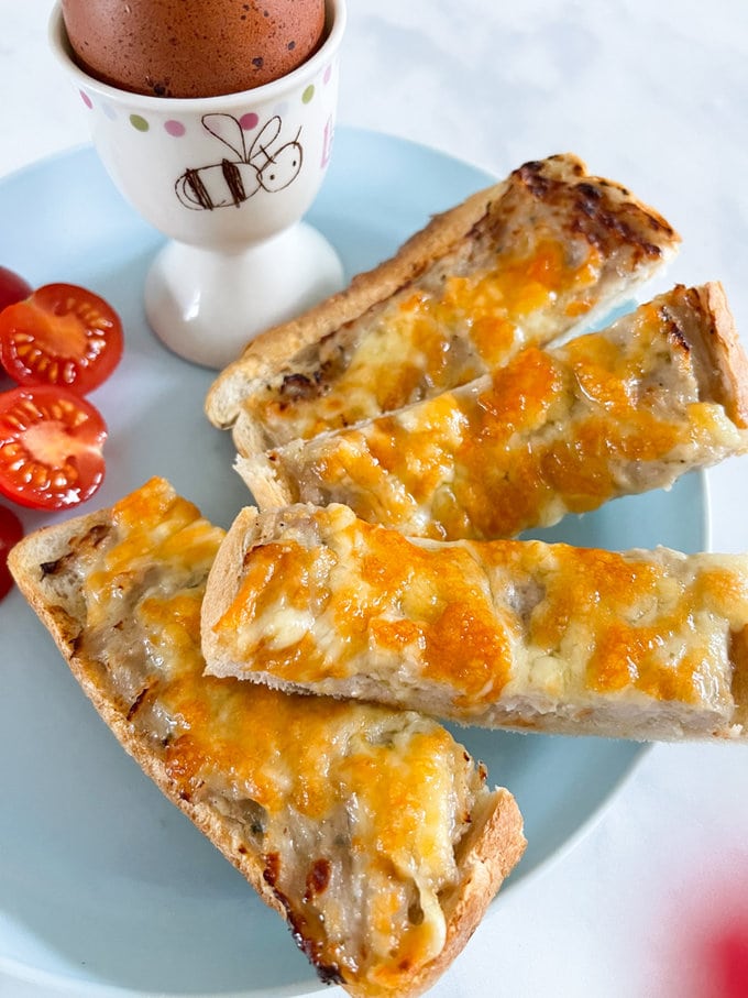 Close up on Airfryer sausage and cheese soldiers arranged on a plate.